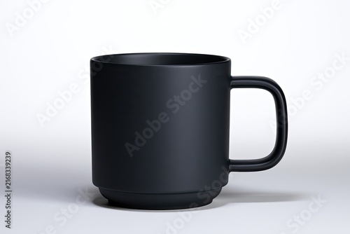 A plain, matte black coffee mug with a simple handle sits on a white surface