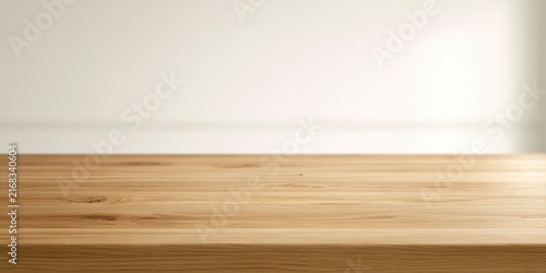 A warm, empty wooden tabletop with a soft, diffused light on a plain background