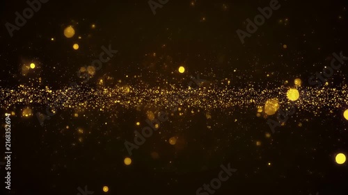Golden particles swirl in cinematic motion against a dark background with copy space for text overlay