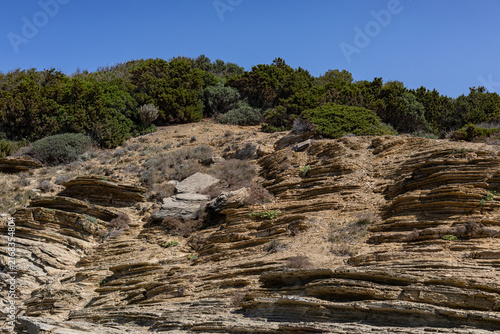 Rocky cliffs of  Buca delle Fate near Populonia, Tuscany, Italy, with rocky cliffs, Mediterranean vegetation.