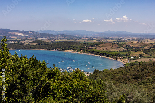 Golfo di Baratti,  near Piombino, Tuscany, Italy, Aerial view  with small boats on the blue sea, green coastline, beaches and lush  Mediterranean vegetation. Scenic view of the Tuscan coast.