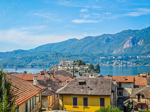 Panoramic view of Orta San Giulio on the shores of Lake Orta, Piedmont, Italy. Aerial drone view showcasing the historic lakeside town and picturesque Alpine landscape