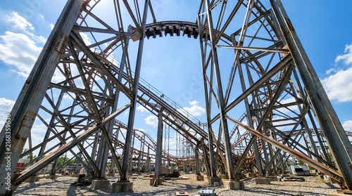 Low Angle Wide Perspective of a Massive Steel Roller Coaster Structure Under a Blue Sky