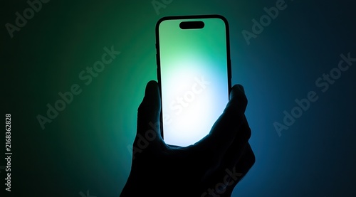 Hand holds glowing smartphone against dark, colorful gradient background