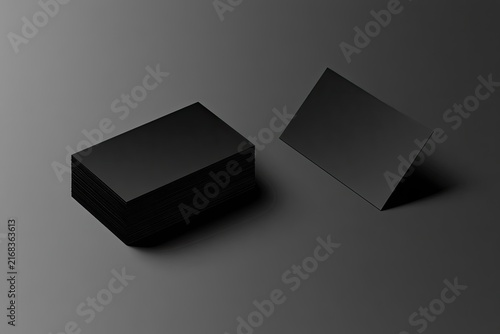 Stack of blank black cards with one card standing, against dark background