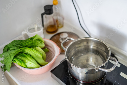 Fotografie Blanching mustard greens: fresh mustard greens and a pot of boiling water