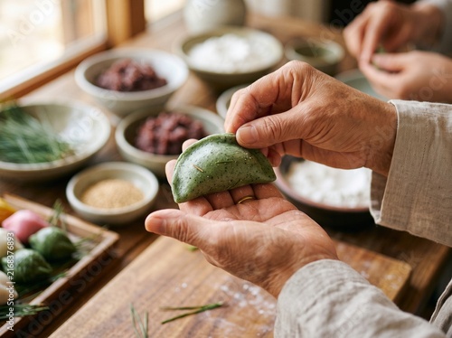 Hands shaping traditional Korean songpyeon rice cakes with colorful fillings on wooden tray