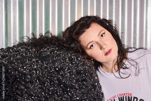 Expressive image of woman resting on textured sculpture surface