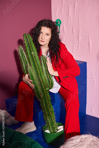 Elegant woman surrounded by lush props in energetic setup