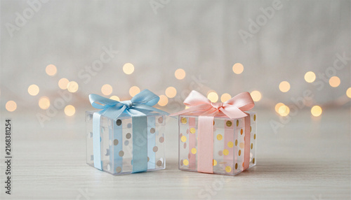 Two gift boxes with pastel bows on a bokeh background