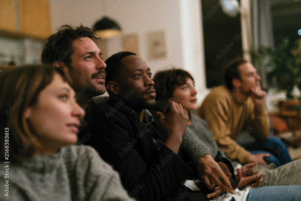 Fototapeta premium A vibrant group of friends sharing joyful moments, captured in a modern living space, highlighting their emotional connection and engagement while enjoying time together.