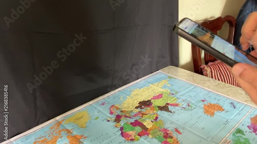 Islamabad, Pakistan - August 20 2026 (editorial): Close-up of a young man holding a smartphone and scrolling through social media reels, watching short video clips while relaxing indoors on a sofa.