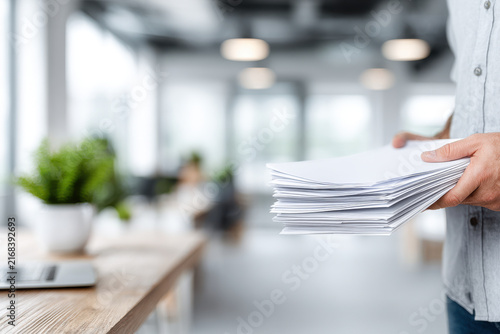 manager holds important documents with abstract ar blurred white text bars overlaying scene