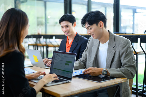 Young Asian Business Team Collaborating with Laptops in Modern Co working Office Space