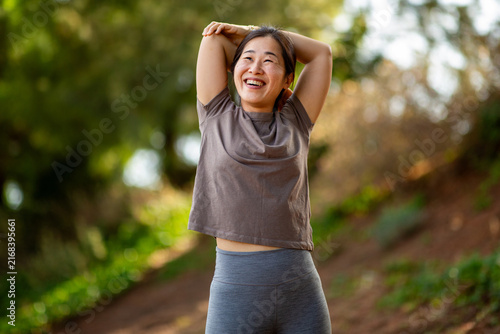 Cuadro en lienzo Asian woman stretching after workout in nature during fitness routine