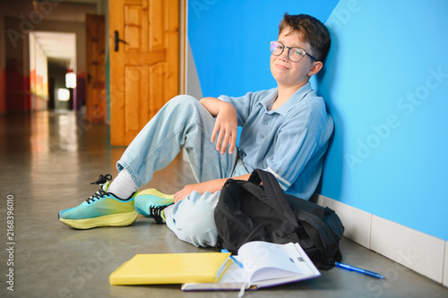 Fotografía Student boy sitting alone in school hallway