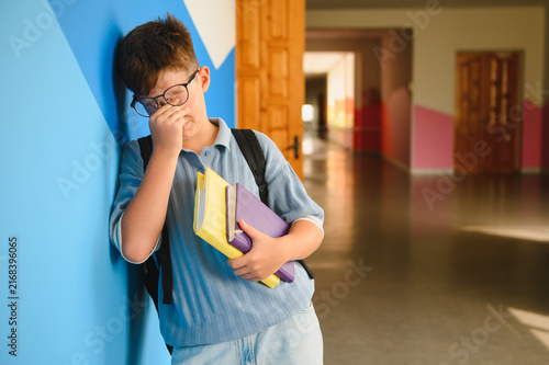 Foto Schoolboy experiencing bullying and stress in hallway