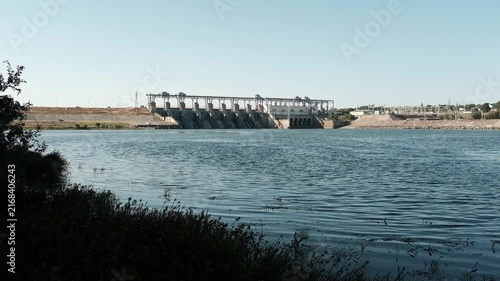 Hydroelectric power station and dam standing across a river. For documentaries on renewable energy,  presentations on clean power generation, environmental reports, or industrial infrastructure.