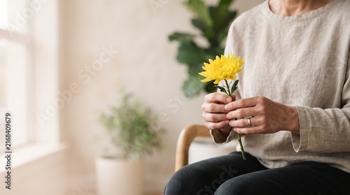 Pessoa adulta segurando delicadamente uma flor amarela sem mostrar o rosto, representando esperança, acolhimento, cuidado emocional e conscientização durante Setembro Amarelo