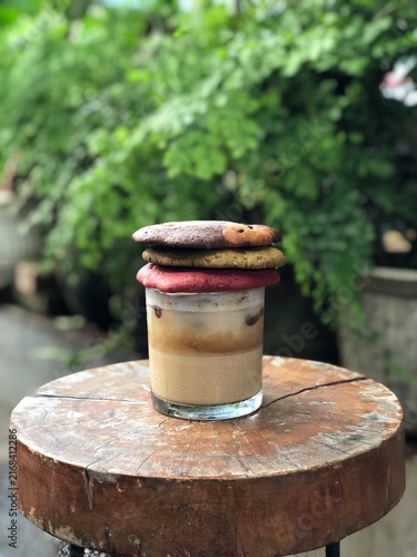 Photography Glass of iced butterscotch coffee topped with stack of three chocolate chip cook