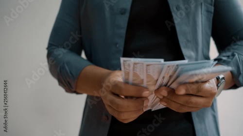 Man investor counting US Dollar bills, close-up. Male trader holds bundle of money, Considers USD at home. Person manages budget.