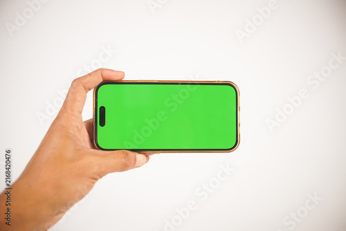 Fotografie Hand Holding Smartphone with Green Screen
