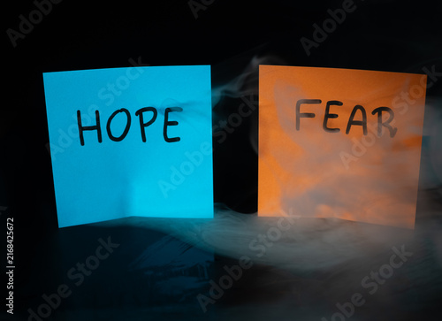 Fotografía Blue sticky note HOPE and orange sticky note FEAR with dramatic swirling smoke on dark background