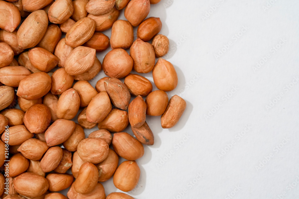 Obraz premium Raw peanut kernels in brown peel in close-up White Background