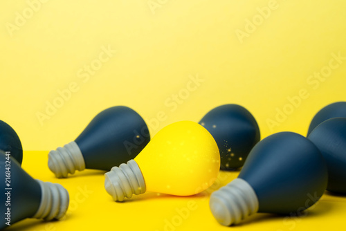 Bild auf Leinwand An idea light bulb shines among others