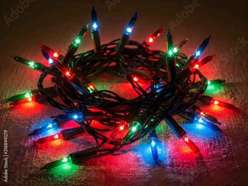 Tangled multicolored christmas lights glowing red green blue on transparent background