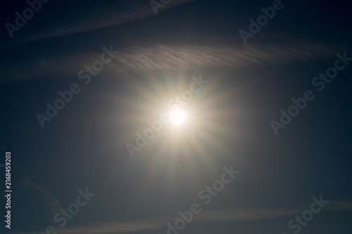 Shining sun in the blue sky with delicate clouds, summer sun in the sky over 27798 Hude, Germany.