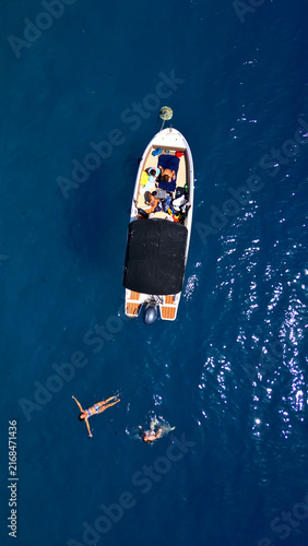 Quadro su tela An aerial shot captures a small boat on the deep blue waters of the adriatic sea, with two snorkelers exploring underwater