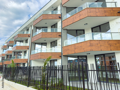 Photography Building with multiple balconies and glass railings in a residential area on a c