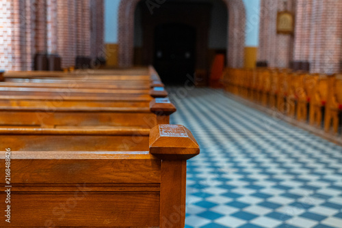 Wooden church pews and checkered tile floor inside historic Gothic church, architectural interior and religious heritage	