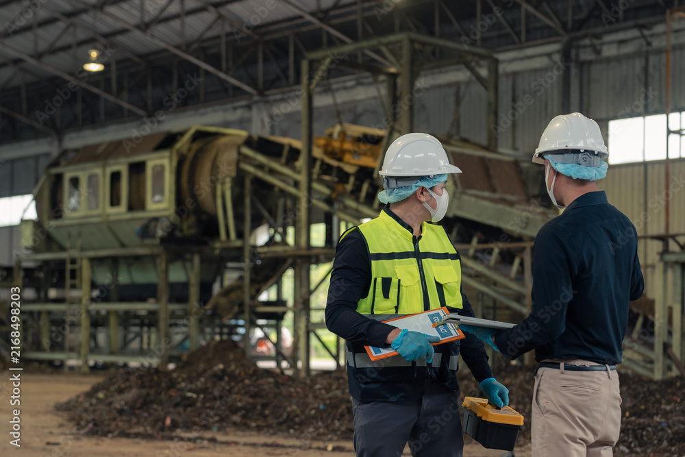 Fototapeta premium Engineers inspecting thermal waste treatment process inside waste management recycling factory.