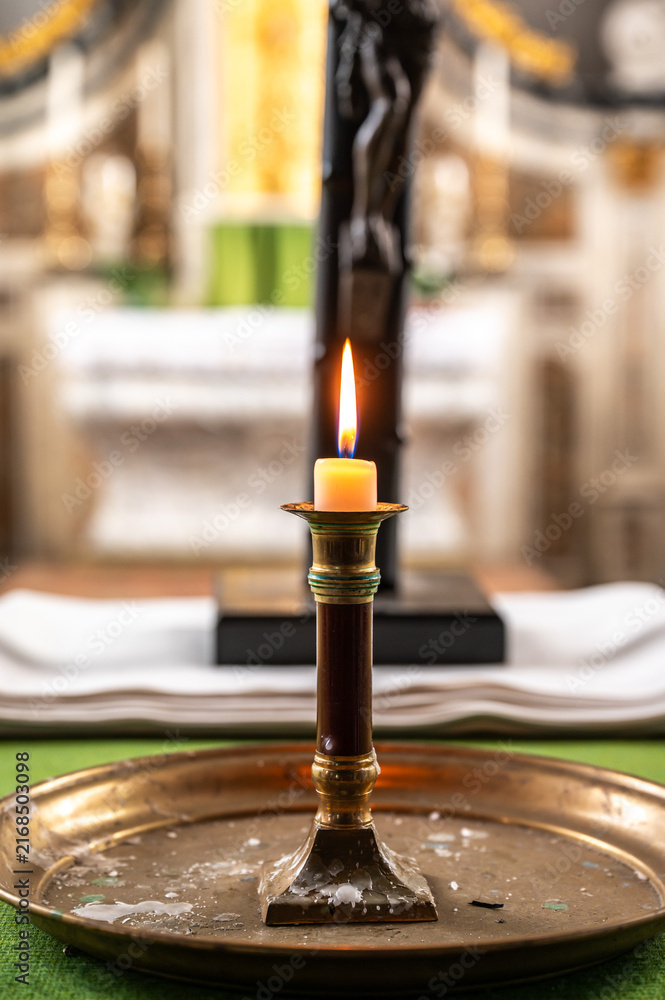 Naklejka premium Candle flame glowing on a church altar