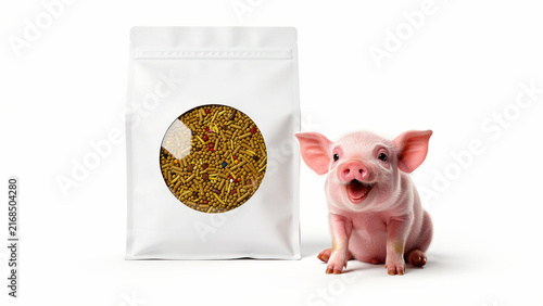 Happy piglet sitting next to a white bag of livestock feed pellets. Small pig smiling beside animal nutrition product on white background. Ideal for farming and pet food marketing concepts.