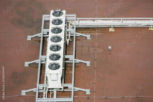 Long white HVAC unit with six circular fans mounted on grey steel frame. Top down architectural perspective. Symmetrical industrial engineering layout with geometric precision.