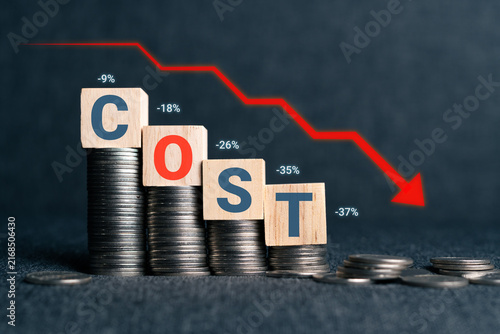 Canvas Print Conceptual image of wooden blocks spelling COST on decreasing coin stacks with a red downward arrow and negative percentages, symbolizing cost reduction, budget cuts, and financial optimization