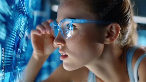 Augmented Reality Interface: A young woman with futuristic glasses interacts with a holographic display, showcasing advanced technology and the future of digital interaction.