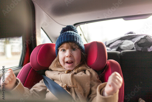 Photography Excited little girl sitting in car seat during road trip