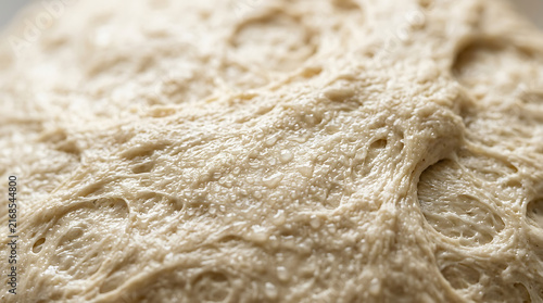 Close-up texture of raw bread dough with air bubbles, baking ingredient macro