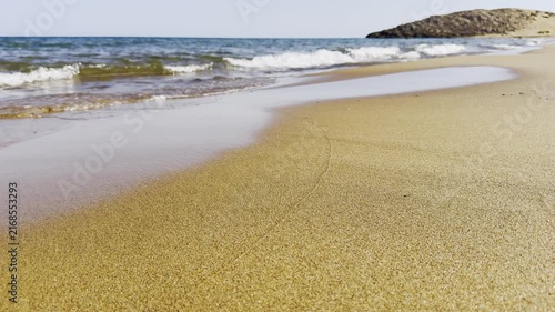Scenic view of ocean waves breaking on sandy shore surrounded by natural coastal beauty perfect for relaxation travel and seaside holiday. High quality 4k footage