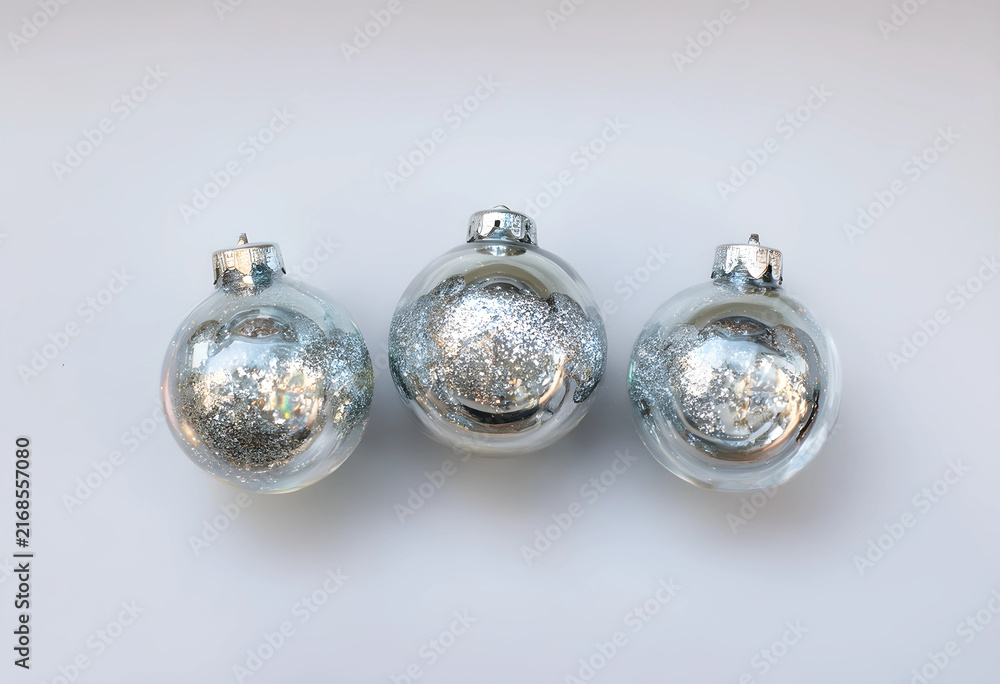 Obraz premium Christmas and new year celebration concept, three silver glitter ornaments on a festive white background