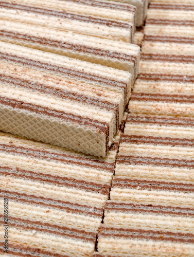 Fresh white wafers with chocolate layers arranged in a supermarket, featuring sweet baked products with visible contrasting layers presented for customers