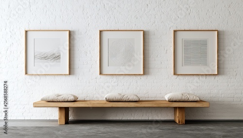 Minimalist display three framed artworks above a wooden bench with cushions