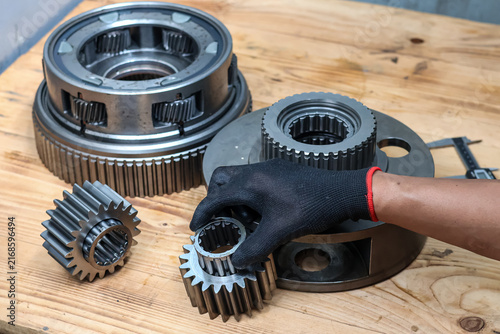 Foto Mechanic Hand Assembling Needle Roller Bearing into Spur Gear on Planetary Transmission Unit
