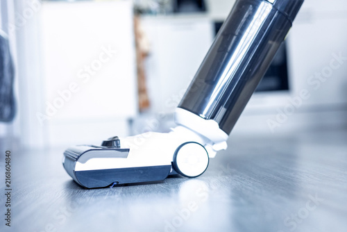 Vacuum cleaner in action on hardwood floor during cleaning process at home