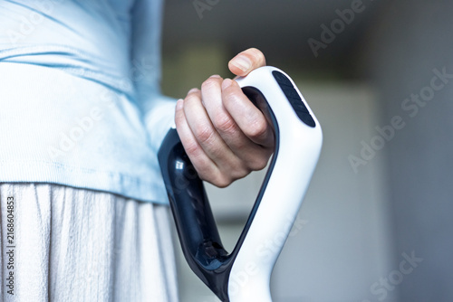 Person holding a walking aid in a home setting during daytime