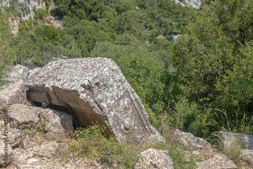 A symbol carved into the stone in an ancient city in the mountains. Termessos is an ancient city located in Turkey. Erosion on the stone. Traces of an ancient civilization.